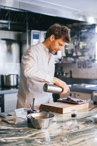 a professional chef using gastronomical equipment to put together his masterpiece