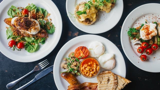 four plates of modern english breakfast: a full english, eggs benedict, and two salads