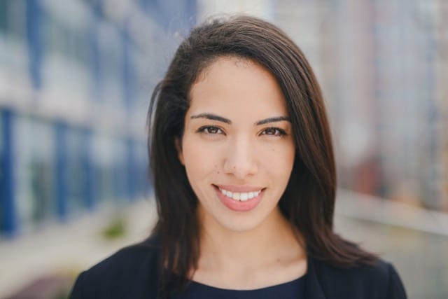 a close up head shot of a young professional lady with brunette hair and formal attire