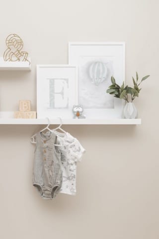 a pair of kid's clothin hanging on a shelf