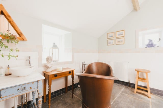 a bright and naturally lit rustic bathroom with modern wooden furniture