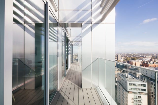 a long balcony on a modern skyscraper, we see materials of glass and metal on a sunny day