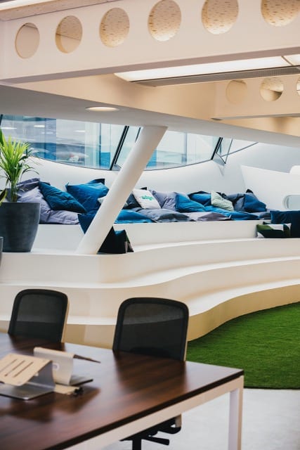 an office's open seating area, which has 5 large steps, lined with bean bags
