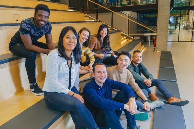 the perfocal team all smile at the camera while sitting on large steps