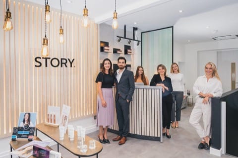 a young team at a health clinic in their reception, which is nicely lit with a strong and beautiful industrial interior