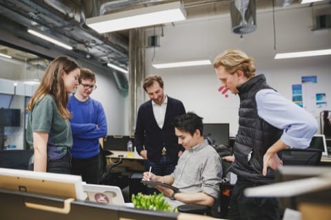 the Perfocal team is around the founder, Tony, looking at his iPad that he is sketching on