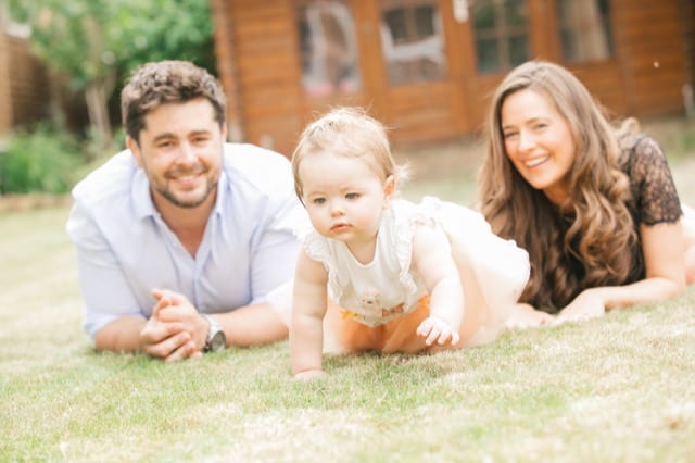 parents and a female baby playing on grass