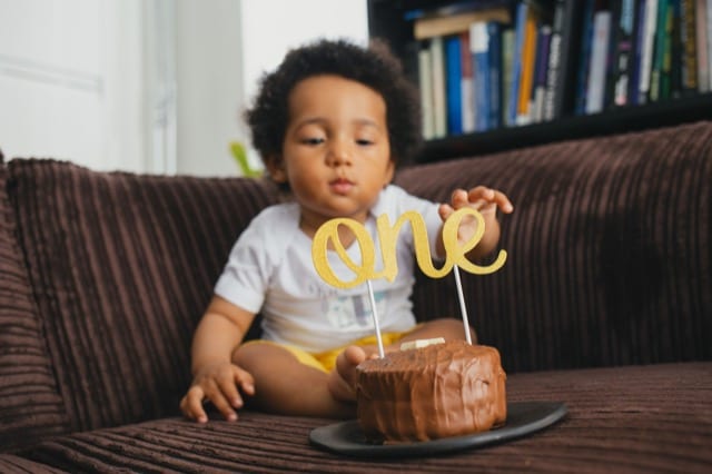 mixed baby celebrating 1st birthday with a cake