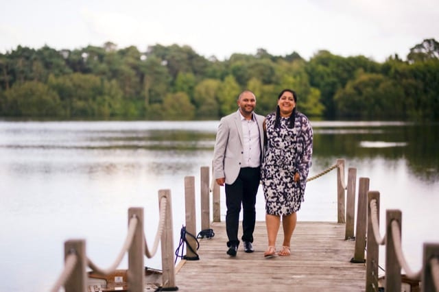Couple walk arm in am towards camera on pier
