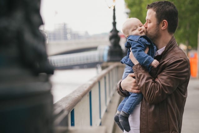 father kissing his baby boy on the southbank of london