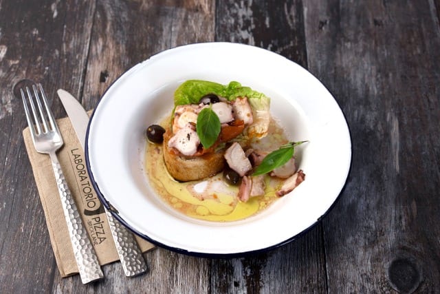 a close up of mushroom bruschetta, accompanied with olives and sweet garlic oil