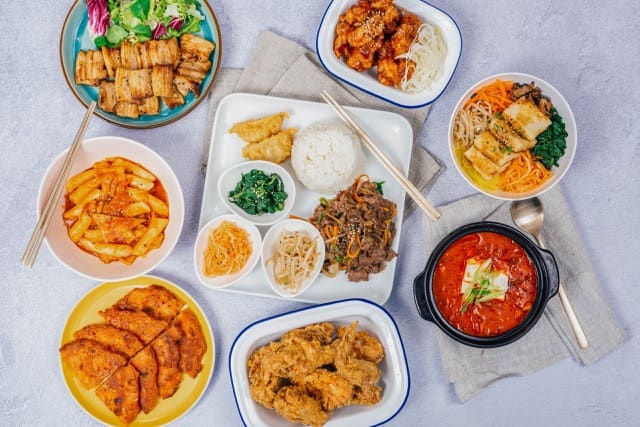 several dishes of korean food including fried chicken, rice and bbq pork
