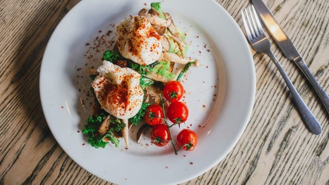 vegetarian dish of paprika poached egg in lettuce cups, accompanied by roasted cherry tomatoes