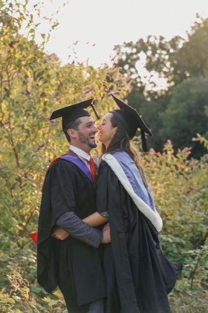 Two graduates hug and celebrate at their graduation photoshoot with Perfocal on a sunny day