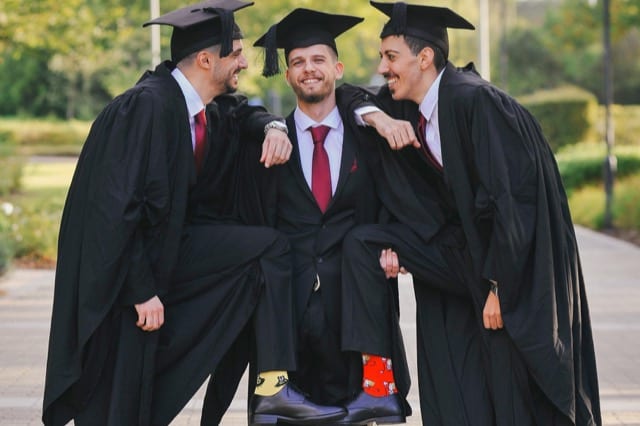 Three brothers pose for their Hertfordshire uni graduation photoshoot showing their colouful socks