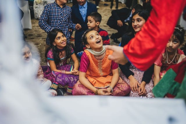 indian kids smiling at performers on a kids party