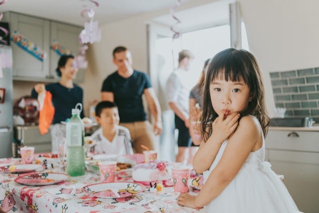 chinese girl's first taste of birthday cake with her fingers
