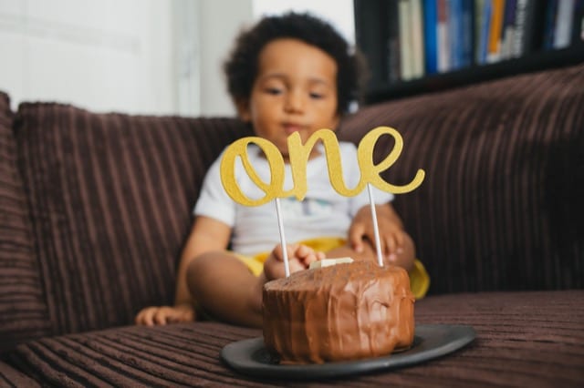 mixed baby boy celebrating his 1st birthday with a cake