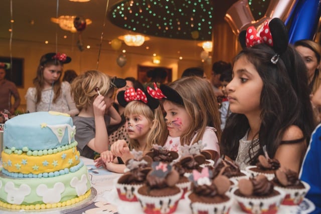 girls on a Micky Mouse themed kids party with cakes