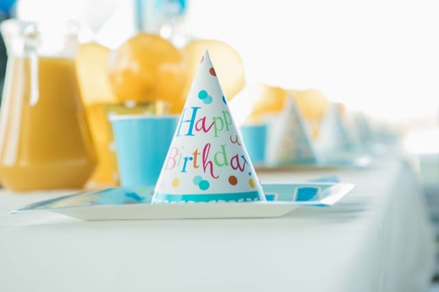 kid's party table set out, with cone party hat for each child