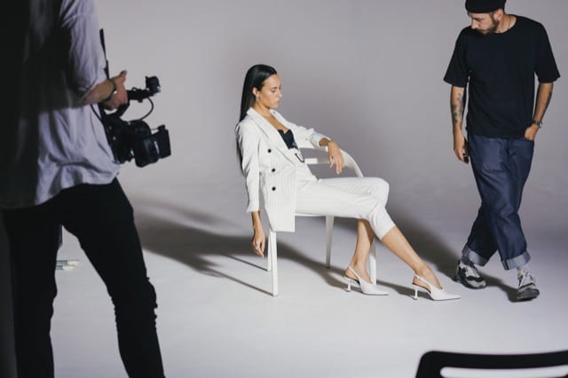 Woman in white pin-striped suit poses in a studio for her Perfocal lifestyle photoshoot