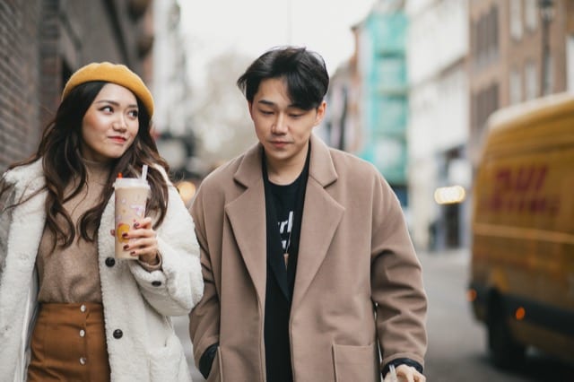 Chinese couple walk through Soho in winter gear and bubble tea for ChaTime's lifestyle photoshoot