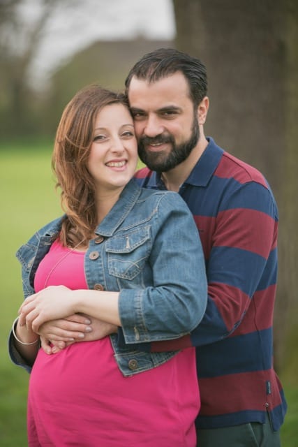 traditional pregnancy photoshoot between a couple both hugging her baby bump