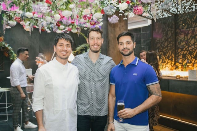 three guys having a group photo taken on a birthday party