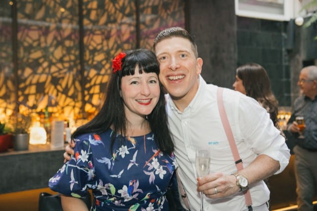Man and woman hug and pose for a photo at their party