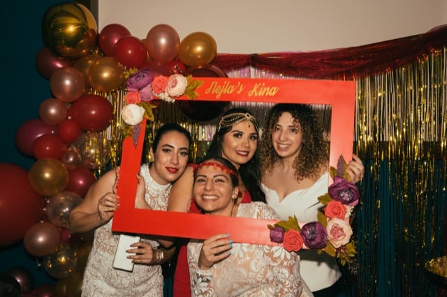 four family friends pose with a photoframe for their hen night photoshoot