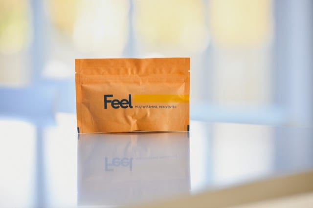 a close up shot of feel brand multi-vitamins packaged in a nice paper bag