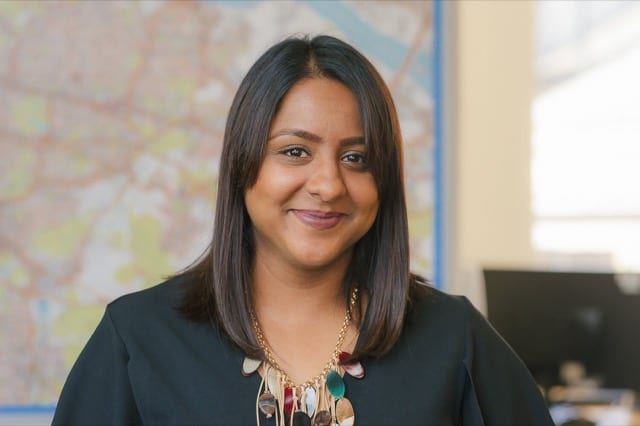 woman with a lobbed haircut smiles for her perfocal headshot in an office