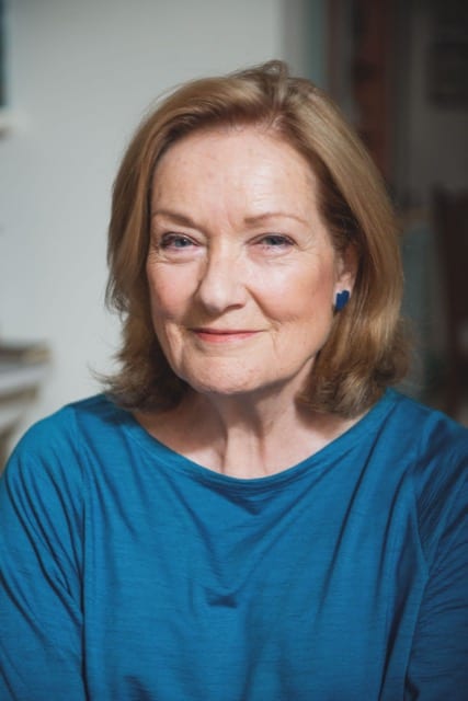 headshot of a woman in a blue top slightly smiling at the camera