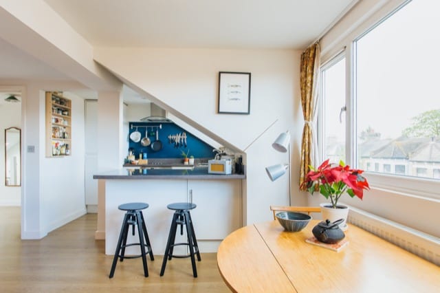 A shot of a breakfast bar alcove with the daylight streaming in from the large window to the right.