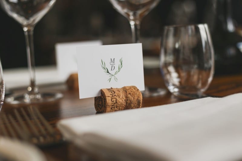 Close up of a minimal name card placed in a cork on a fully dressed wedding table.