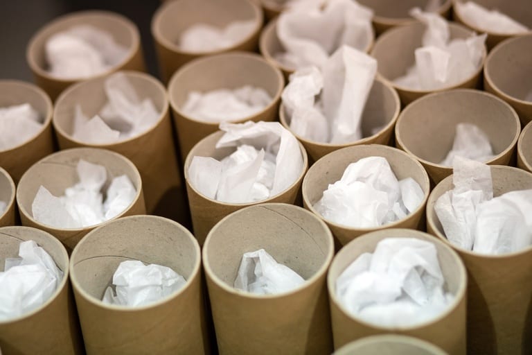 Many cardboard tubes next to each other, all full of art prints.